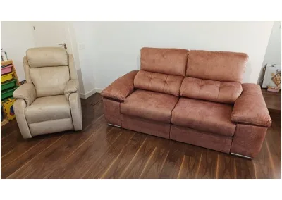 Sofá chaislongue Ares con asientos deslizantes, brazos con arcón y tapizado personalizable en un salón moderno.